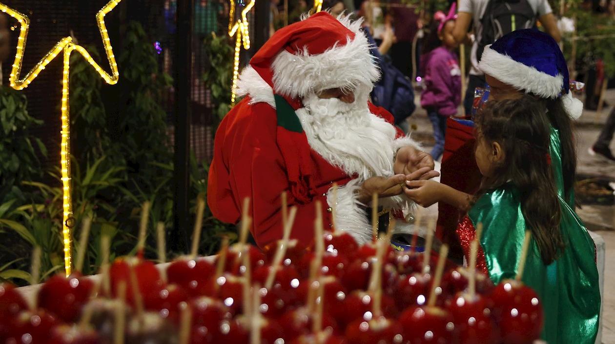 Hombre vestido como Papá Noel compartiendo con los niños.