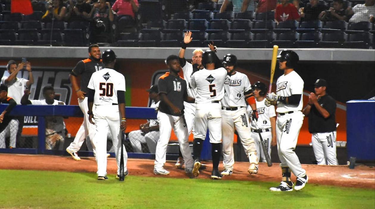 José Rosario festeja una anotación con sus compañeros de los Gigantes.