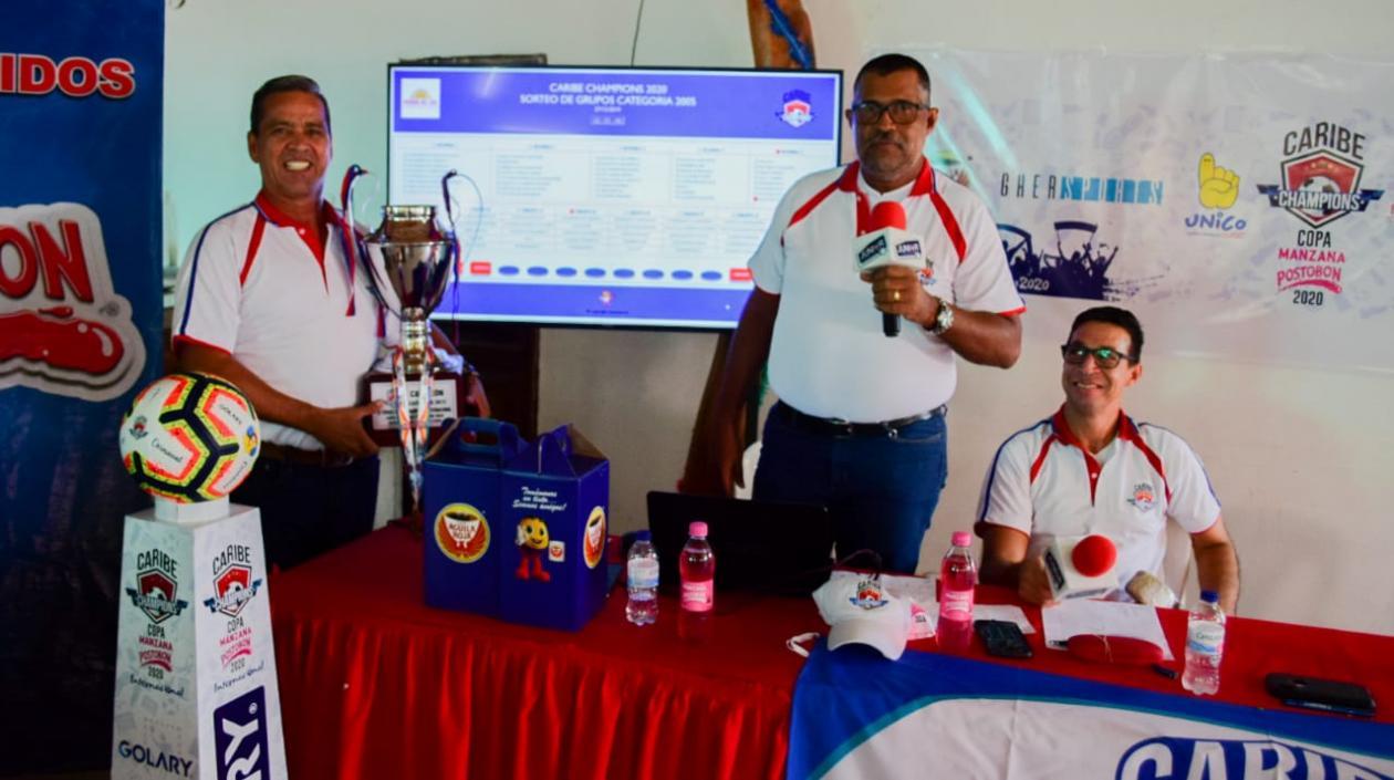 Carlos Bolívar (izquierda), director del torneo, sostiene el trofeo.