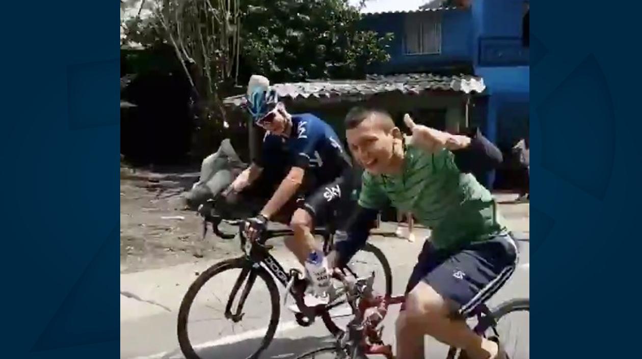 Chris Froome al lado de un aficionado. 