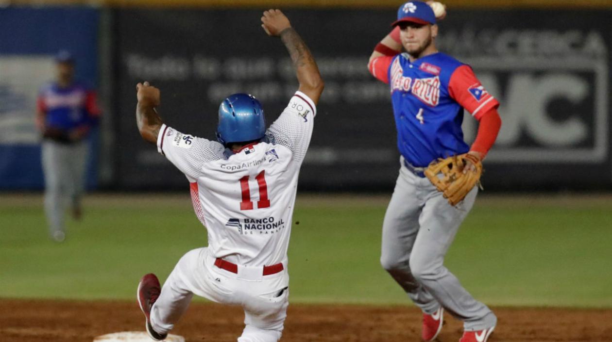 Elmer Reyes de los Toros de Herrera de Panamá intenta llegar a la base antes de ser puesto out por Alexis Pantoja.