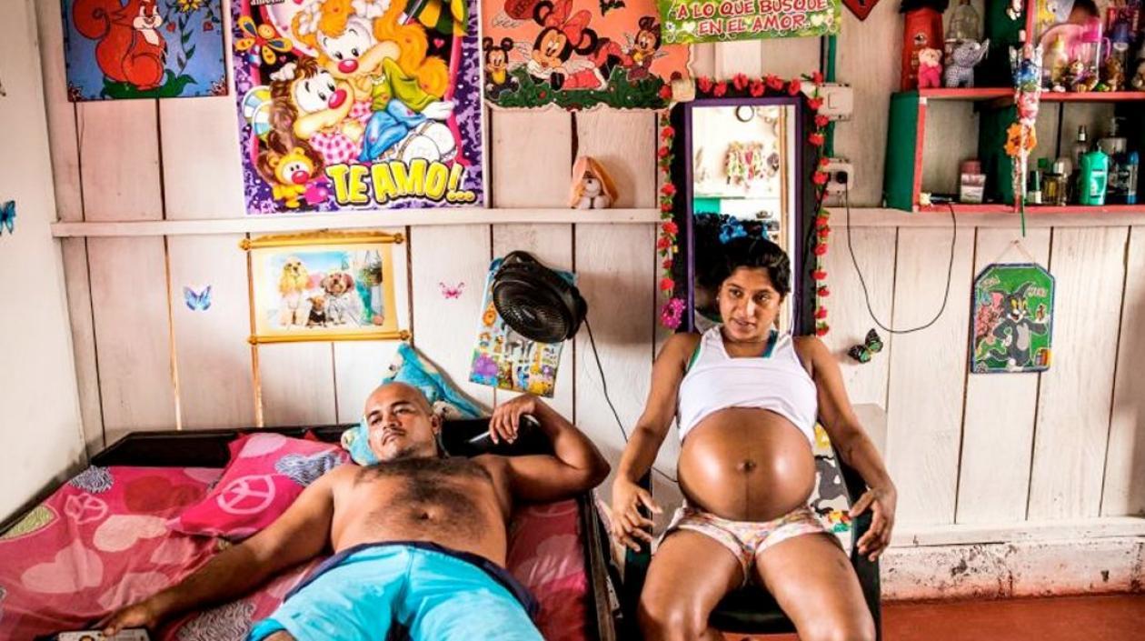 Yorladis, sentada en su habitación con la camiseta medio levantada.