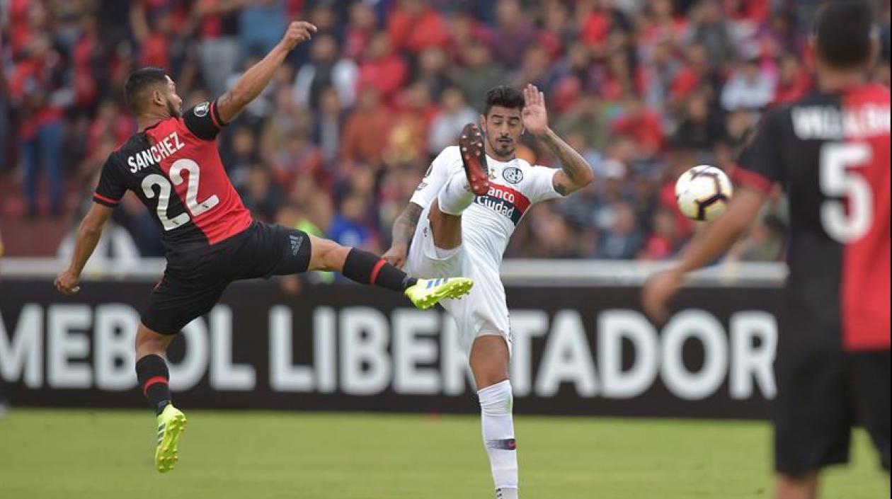 Joel Sánchez (i) de Melgar disputa el balón con Román Martínez (c) de San Lorenzo.