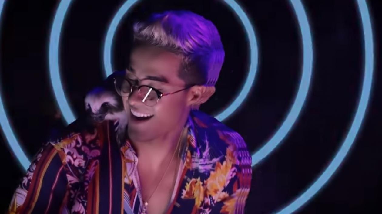 El cantante de reguetón Juan Mindiola con un mono tití en el hombro.