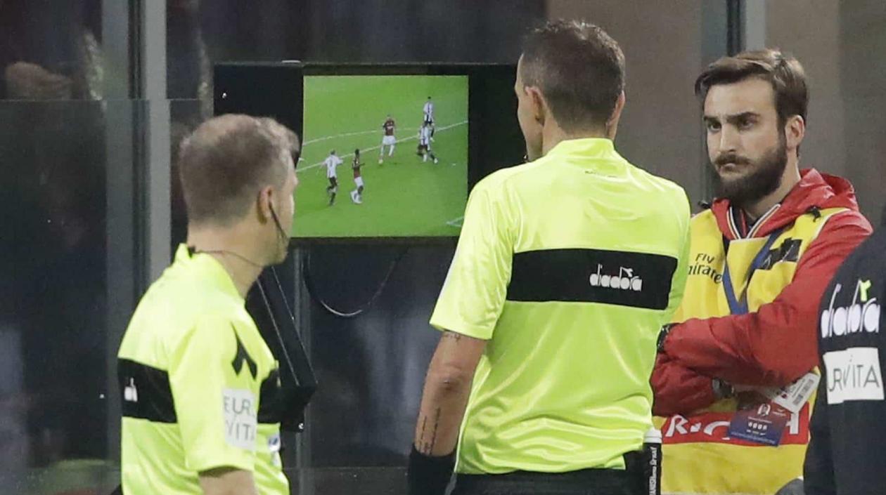 Árbitros observan una jugada repetida en el sistema del VAR. 