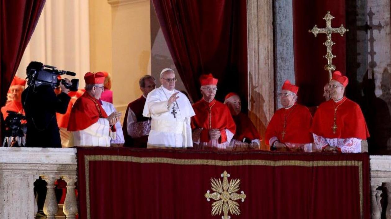 El cardenal argentino Jorge Mario Bergoglio (c) saluda desde el balcón tras ser elegido Papa en la plaza de San Pedro de la ciudad del Vaticano el 13 de marzo de 2013.