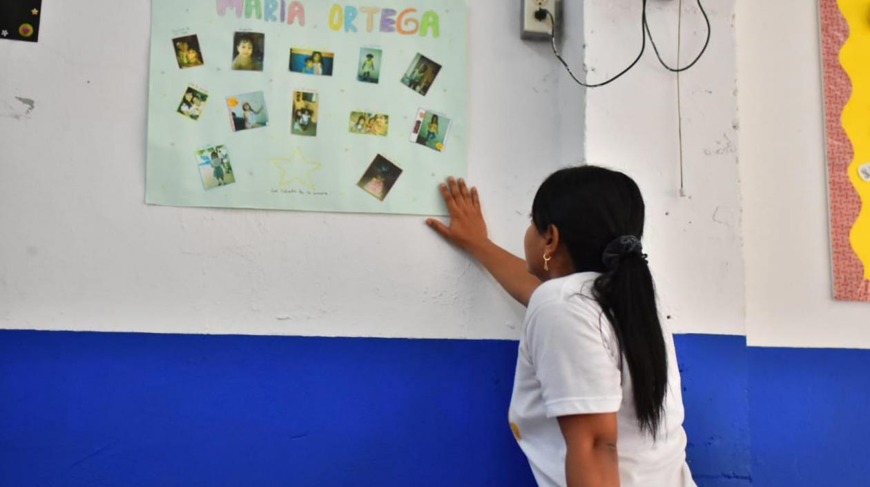 La profesora Shirley Pardo observa la cartelera de reconocimiento a María José.
