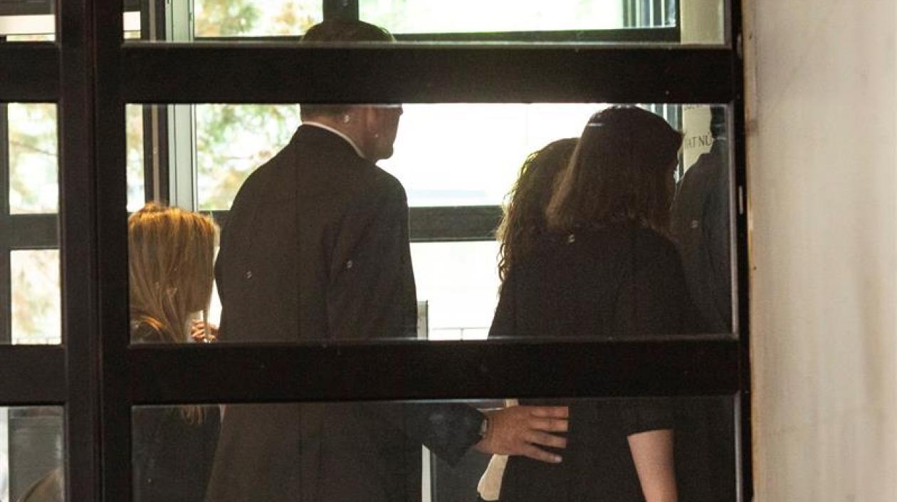 La cantante Shakira (al fondo, tapada) ha eludido este jueves a la prensa que la esperaba a las puertas del juzgado de Esplugues.