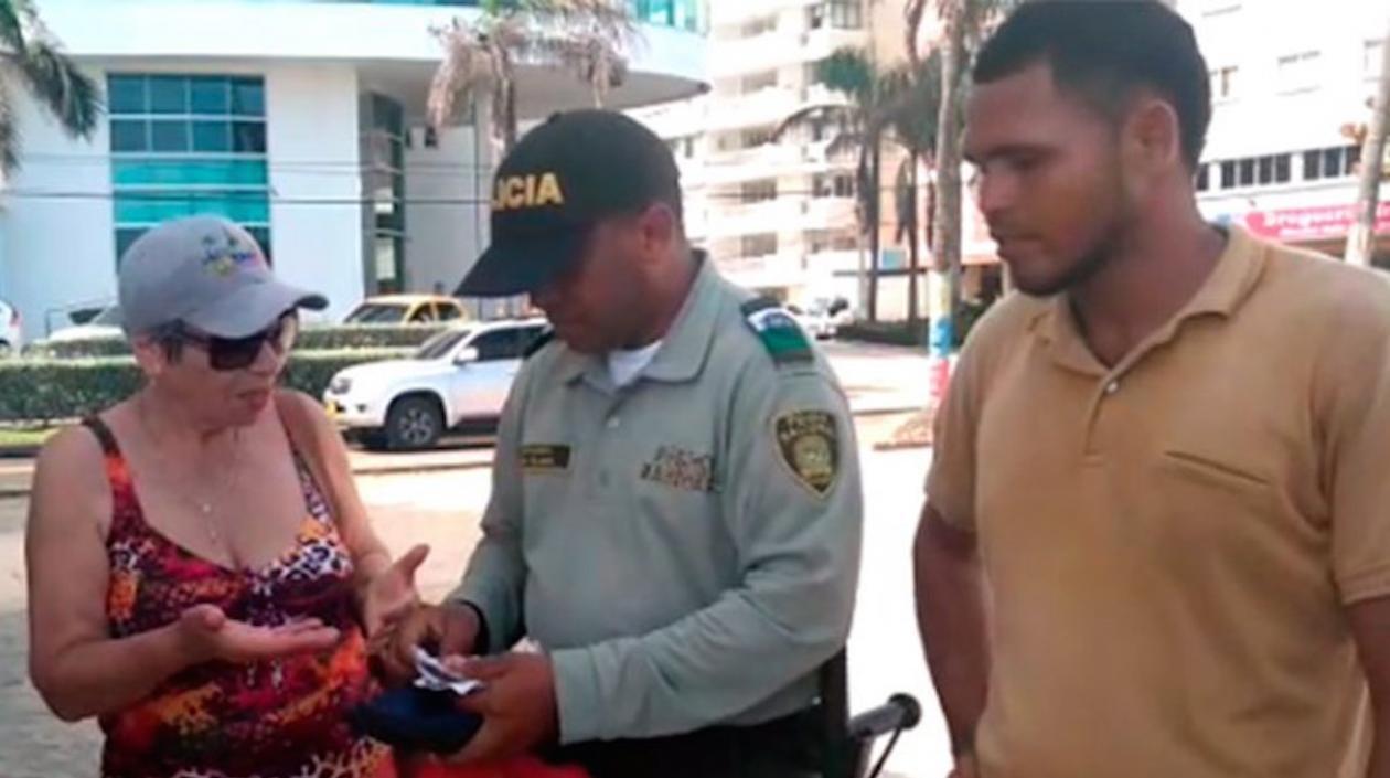 La turista contando lo sucedido delante del vendedor que fue sancionado.