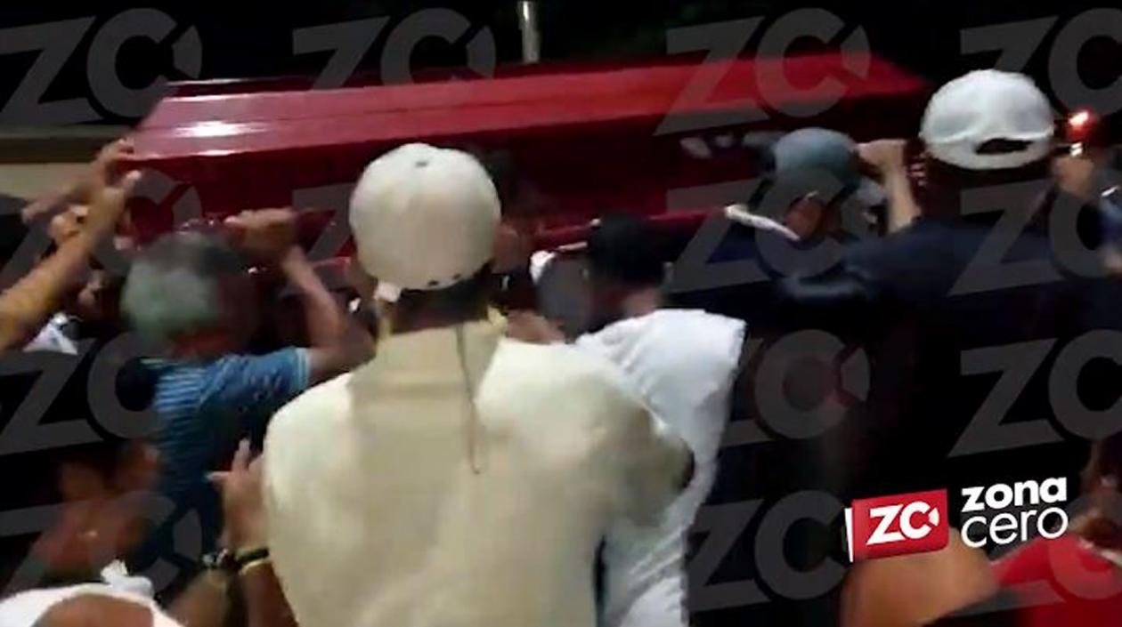 Momento en el que vecinos y amigos cargan el cajón con el cuerpo equivocado.