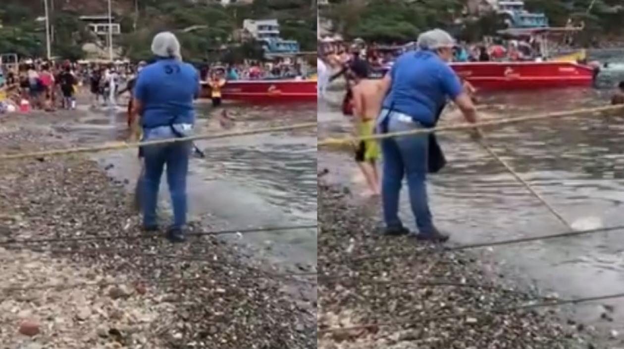 Una mujer lava un trapero en la bahía de Taganga.