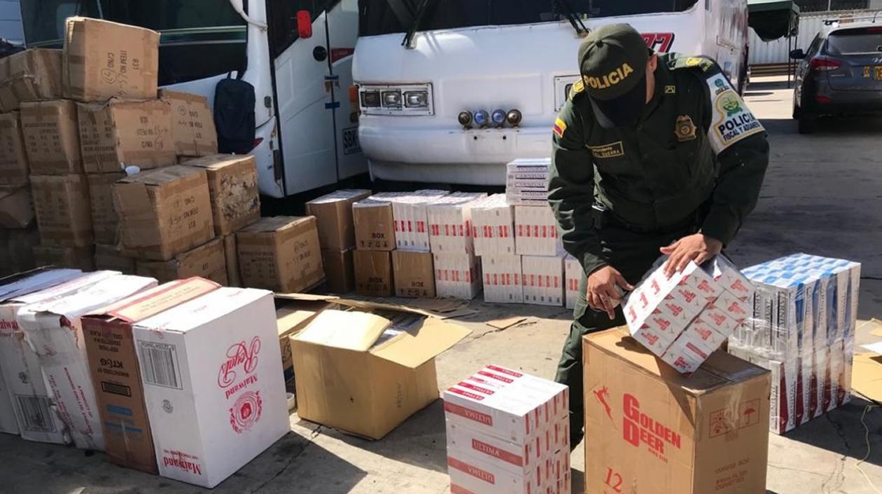 Un policía inspecciona el bus cargado de mercancía de contrabando.
