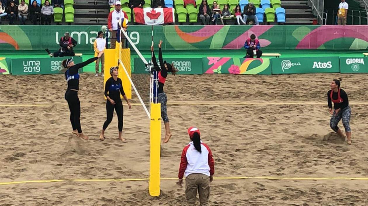 Las jugadoras de Estados Unidos rematan en la red ante la defensa de Colombia. 