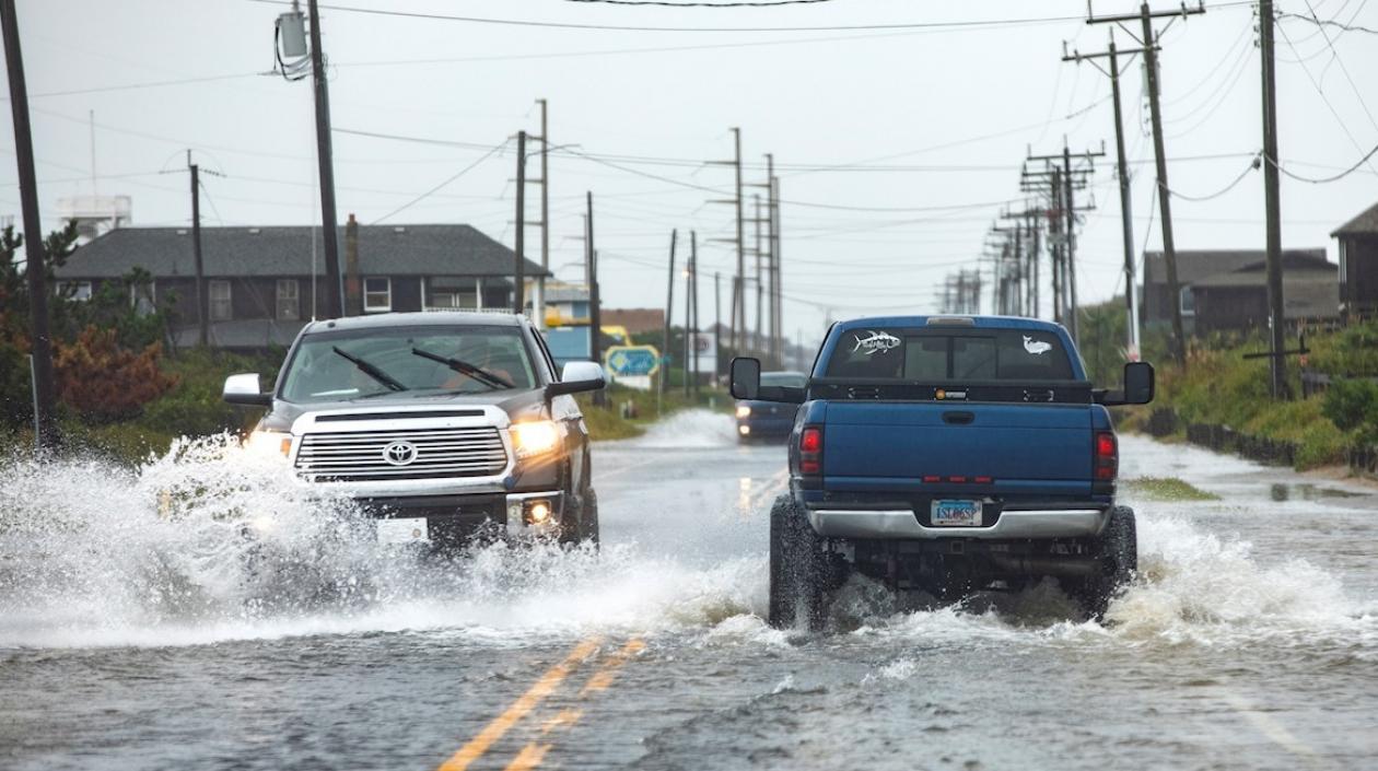 Dos carros en medio del agua transitan por Carolina del Norte.
