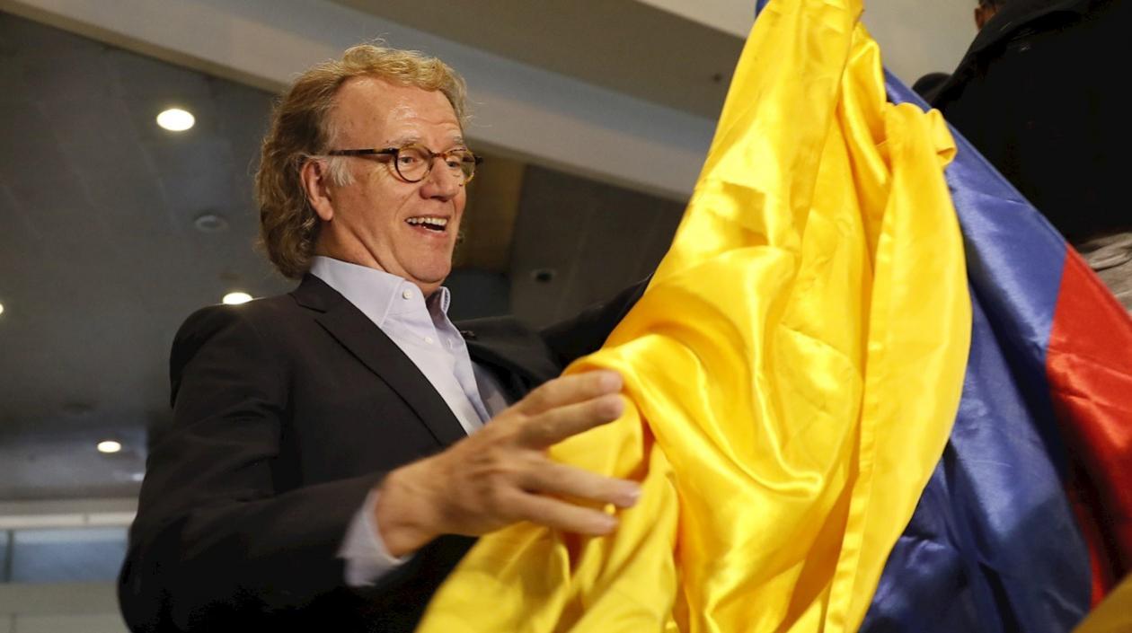 El violinista de Países Bajos André Rieu enarbola este lunes una bandera colombiana tras arribar al Aeropuerto Internacional El Dorado, en Bogotá (Colombia)