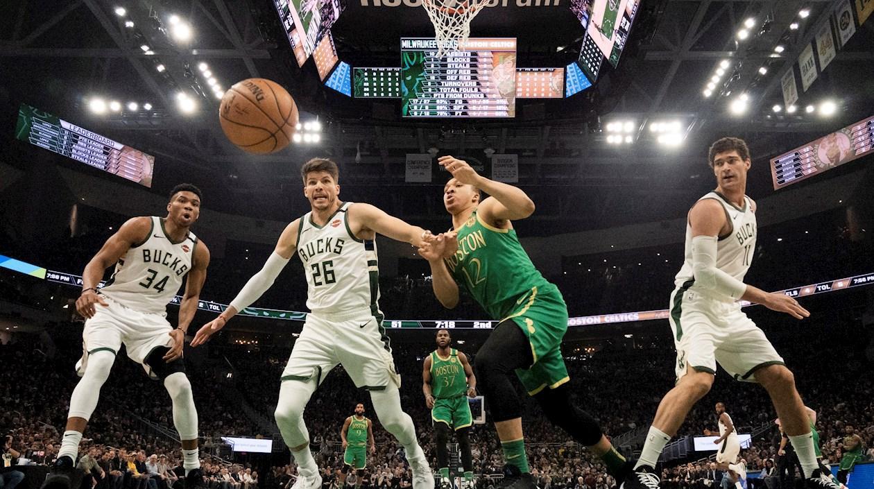 Jugadores de los Bucks observan a la pelota salir por la línea de fondo. 