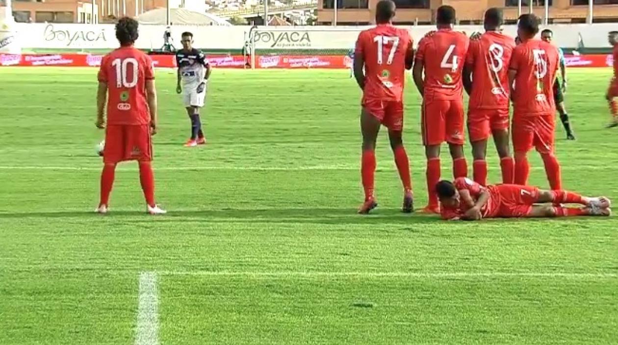 Cristian Barrios se acuesta detrás de la barrera ante el cobro de tiro libre de los junioristas.