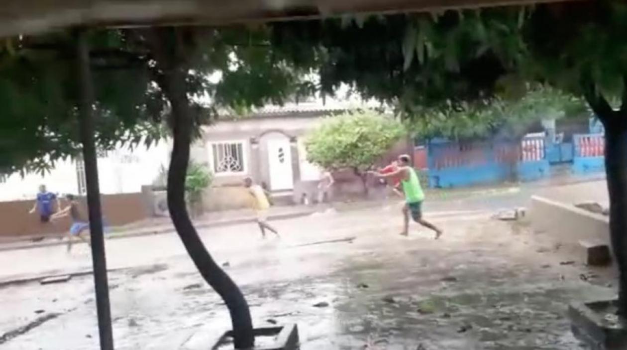 Jóvenes disparando sus armas de fuego durante el enfrentamiento.