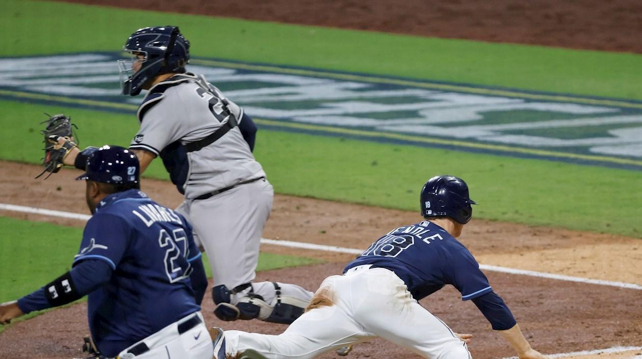 Joey Wendle anota ante la vigilancia de Gary Sánchez. 