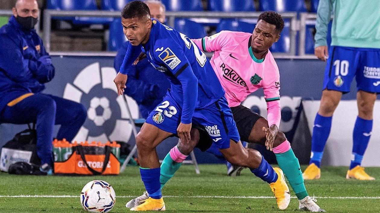 'Cucho' Hernández escapa de la marca de Ansu Fati. 