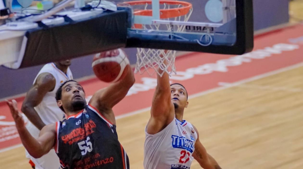 Jonathan Rodríguez encesta para Titanes, ante el acoso de un rival. 