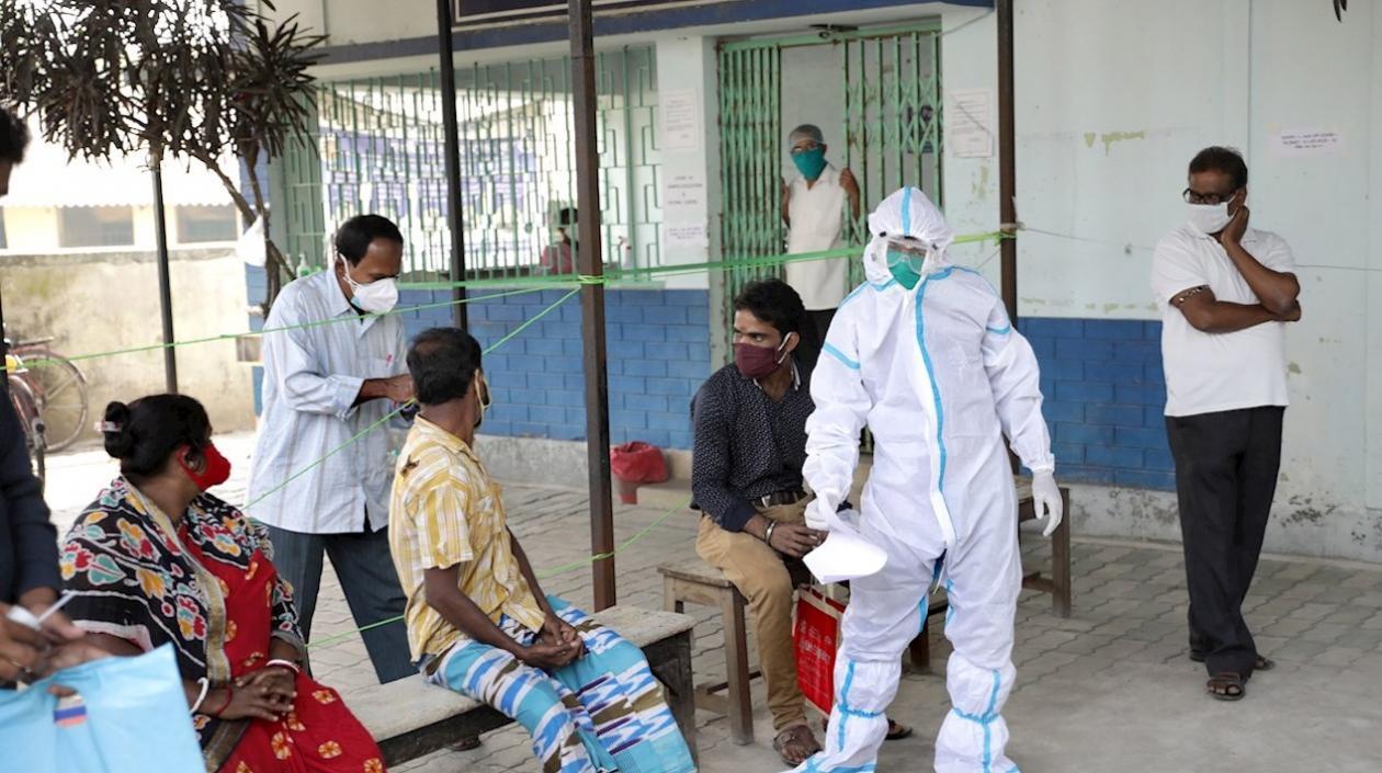 Varias personas esperan su turno para realizarse un test de coronavirus en un centro de salud de Calcuta, India. 