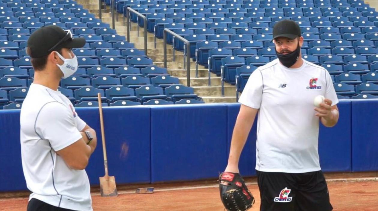 El mánager de Caimanes, José Mosquera, habla con el lanzador David Holmber.