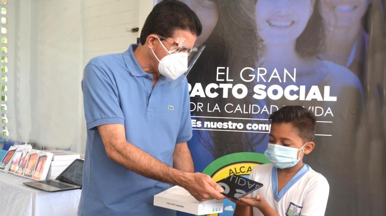 El Alcalde Rodolfo Ucrós entregando la tablets a uno de los estudiantes.