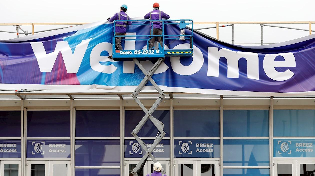 Obreros trabajan en el aviso de bienvenida al Mobile World Congress en Barcelona.