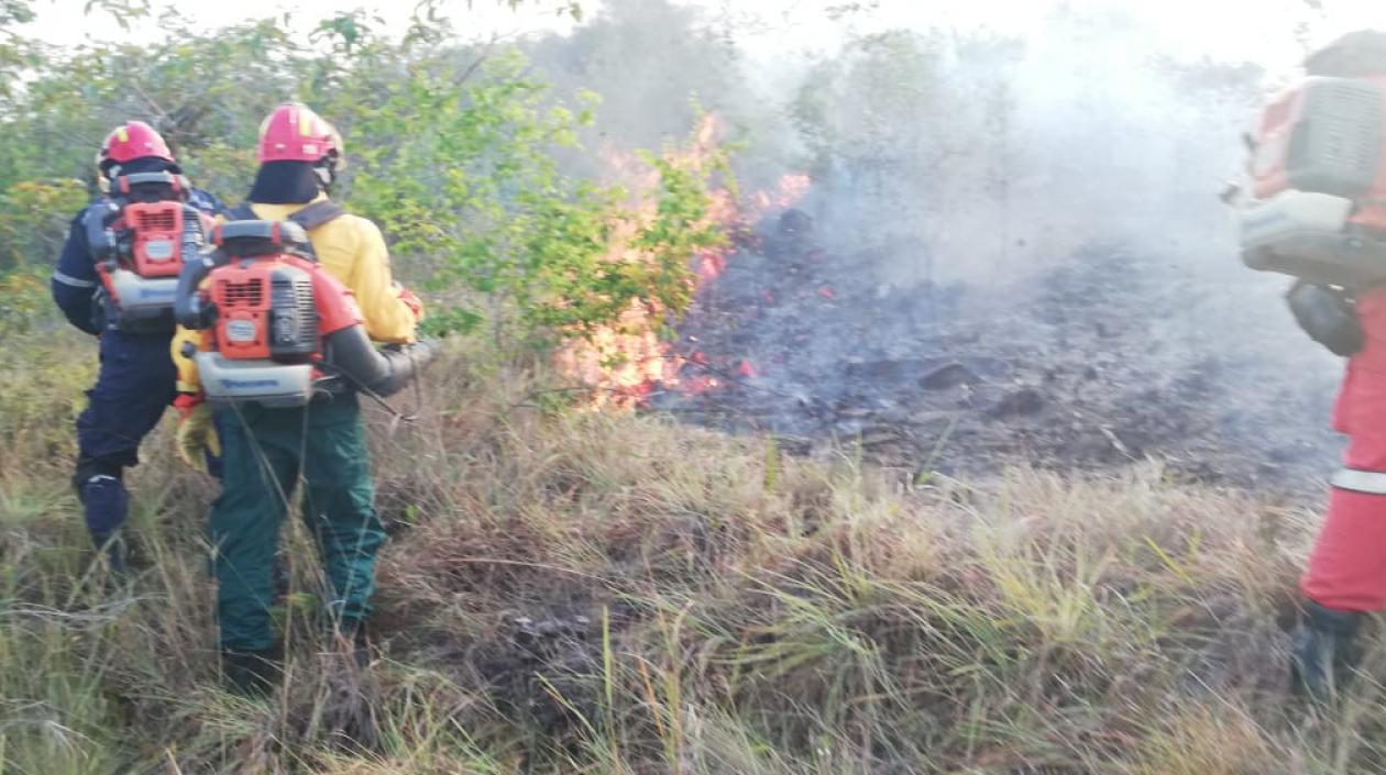 El incendio es controlado por bomberos.