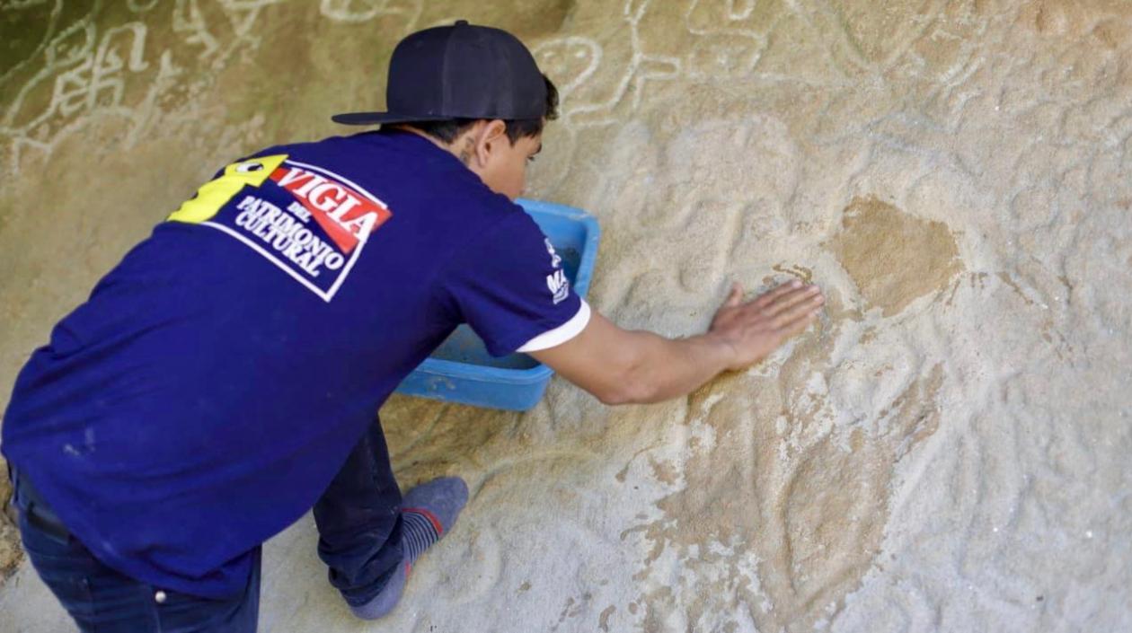 Uno de los 7 Vigías del Patrimonio restaurando la figura.