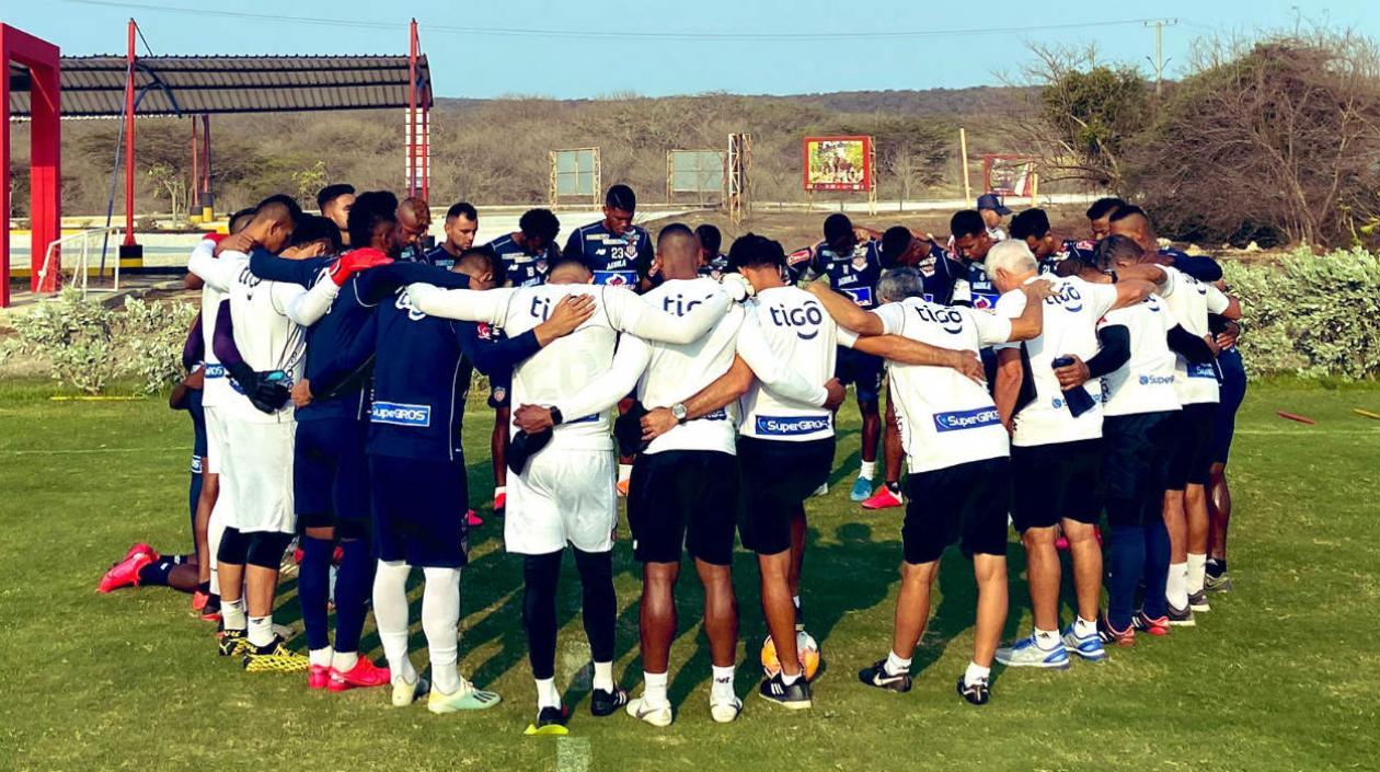 Jugadores de Junior reunidos con los entrenadores antes de iniciar un entrenamiento. 