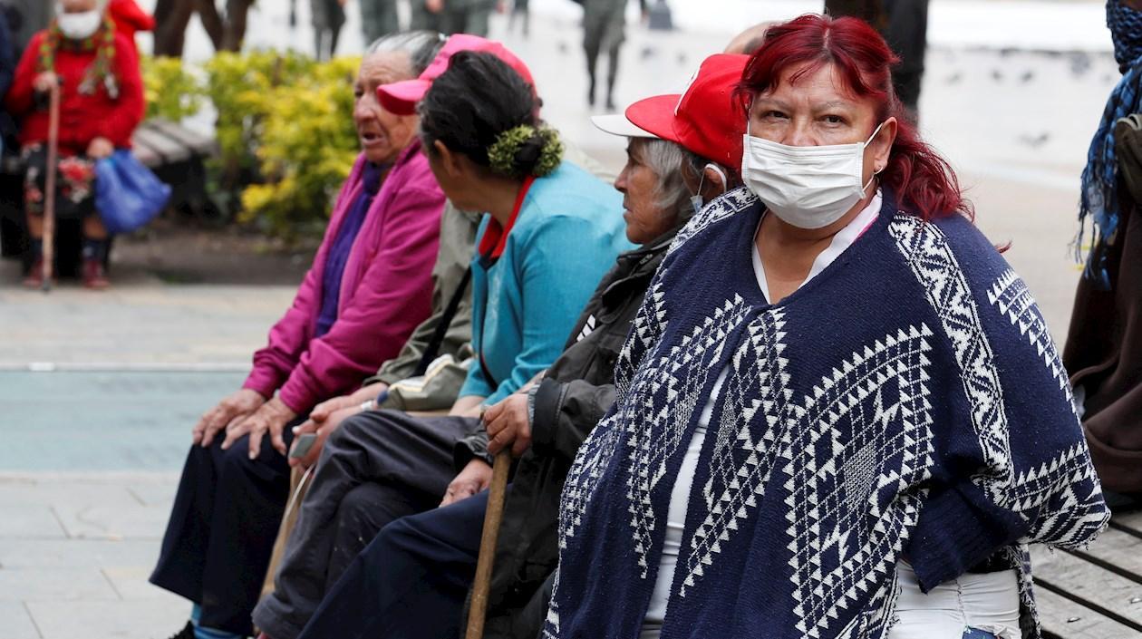 Adultos mayores sentados en un parque.
