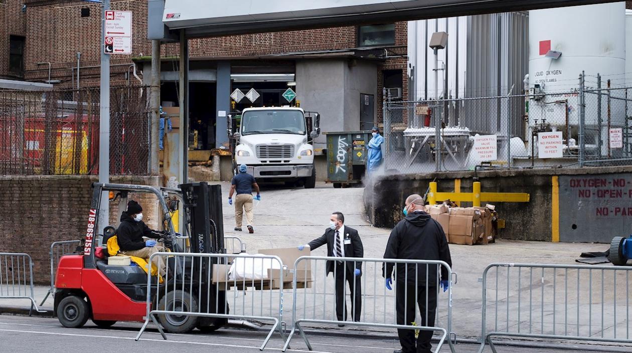 Los empleados del hospital transfieren un cuerpo en una carretilla elevadora a una morgue móvil temporal, puesto en su lugar debido a la falta de espacio en el hospital, fuera del Brooklyn Hospital Center en Brooklyn.