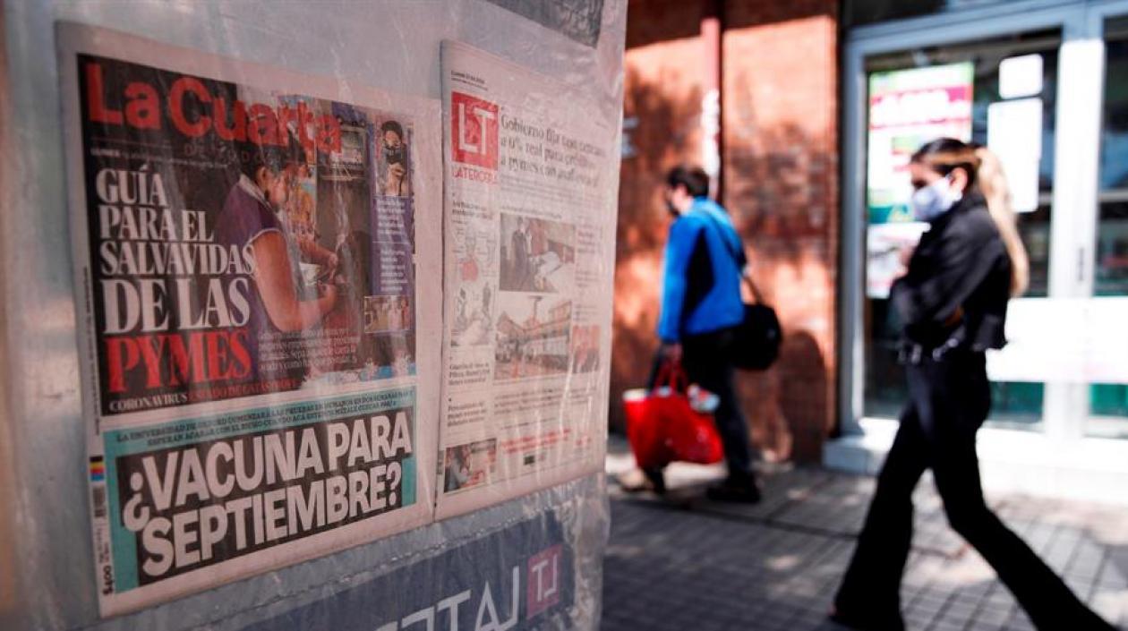 Una mujer, con tapaboca, camina junto a un kiosko en la comuna de Providencia en Santiago (Chile).