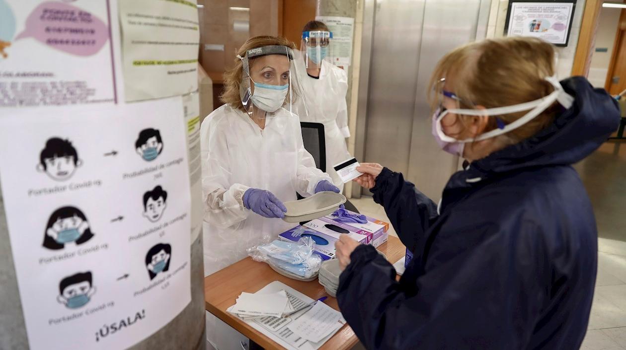 Trabajadores sanitarios del centro de salud de General Ricardos, en Madrid, atienden a una paciente. 