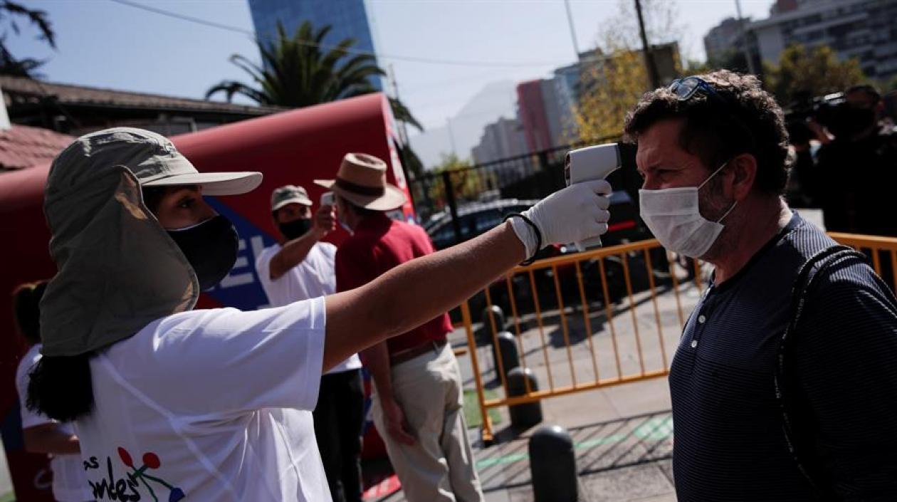 Toma de temperatura a personas que van a abastecerse en centros comerciales de Santiago de Chile.