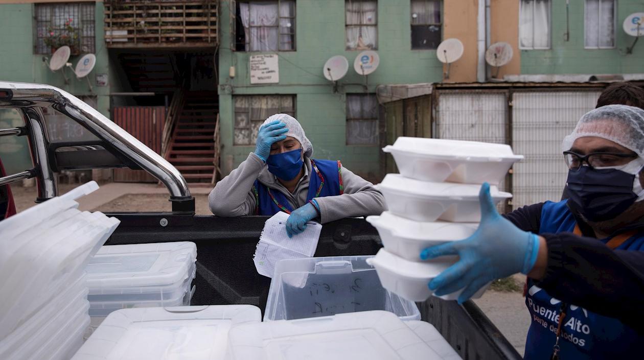 Dirigentes vecinales y trabajadores municipales reparten almuerzos a familias vulnerables en la comuna de Puente Alto el 12 de mayo de 2020, en Santiago (Chile).