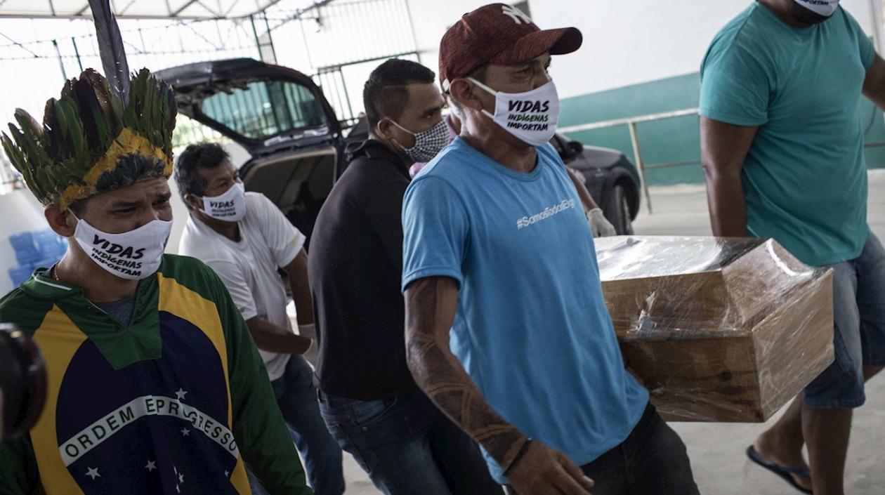 Un grupo de hombres carga el féretro del cacique Messías Kokama, de 53 años, víctima de covid-19, durante su funeral en el Parque de las Tribos este jueves,