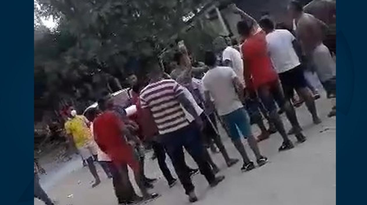 Agrupados, sin tapabocas, viendo la pelea de gallos.