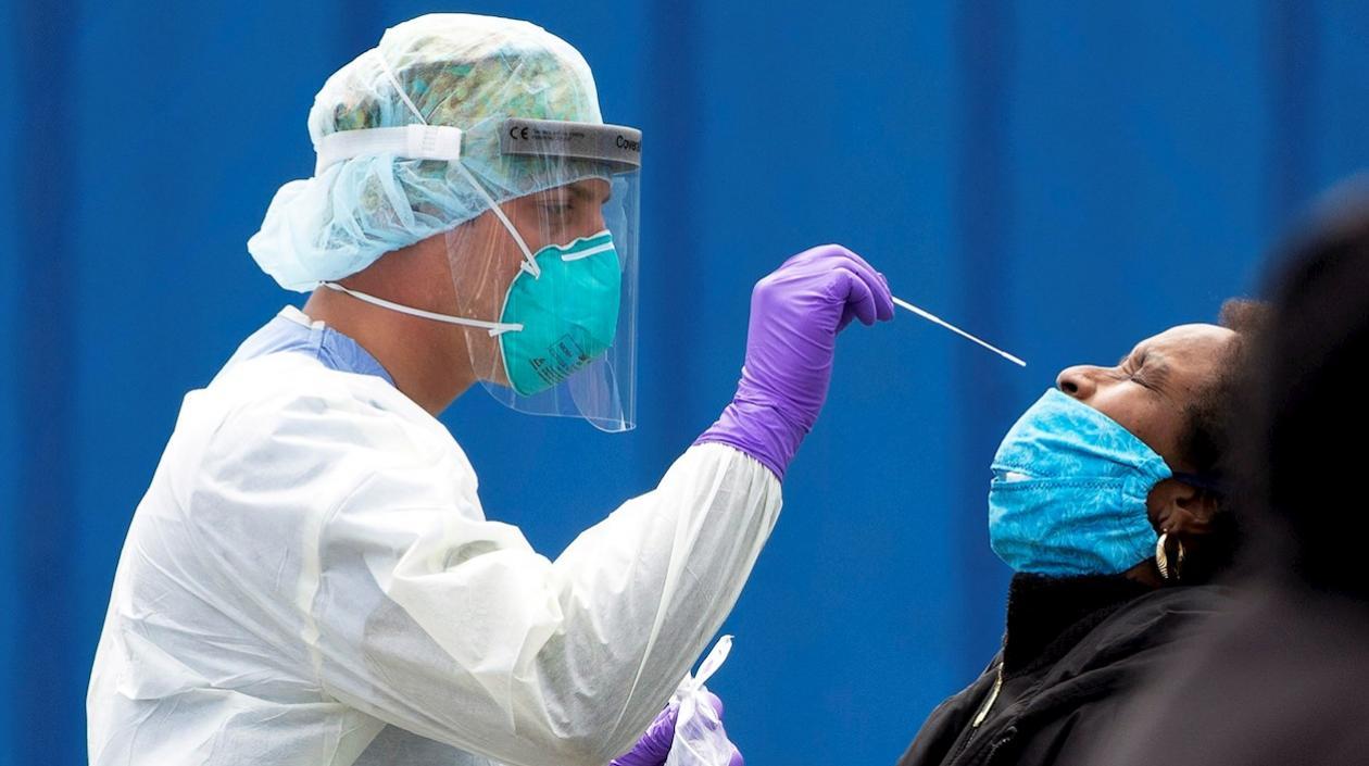 Un hombre toma una muestra a una paciente.