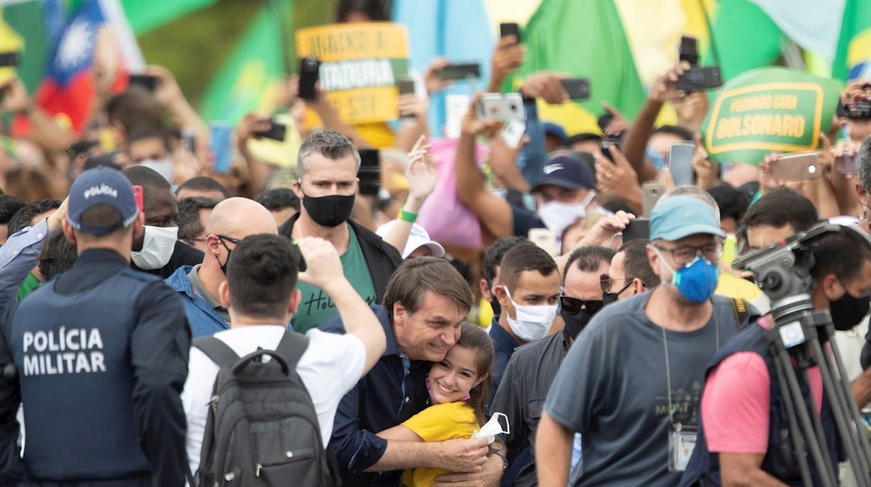 El presidente de Brasil, Jair Bolsonaro, saluda a una niña este domingo, en Brasilia (Brasil).
