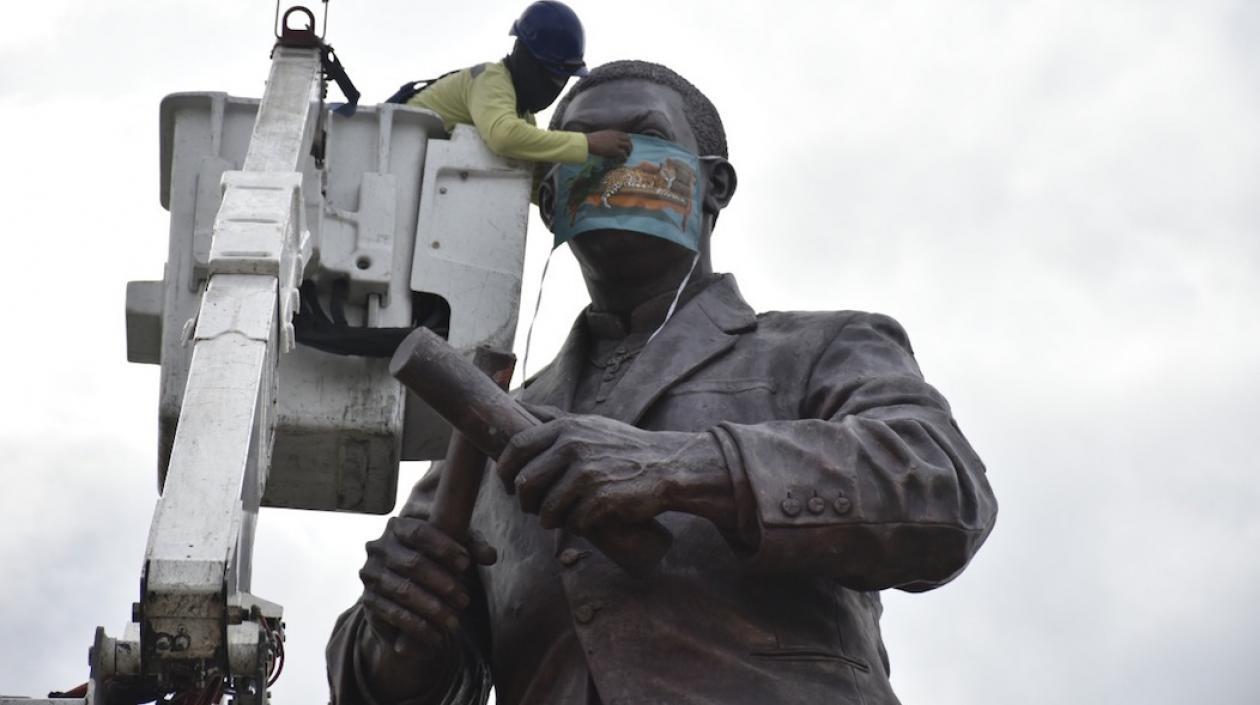 Colocación del tapabocas al monumento del Joe Arroyo.