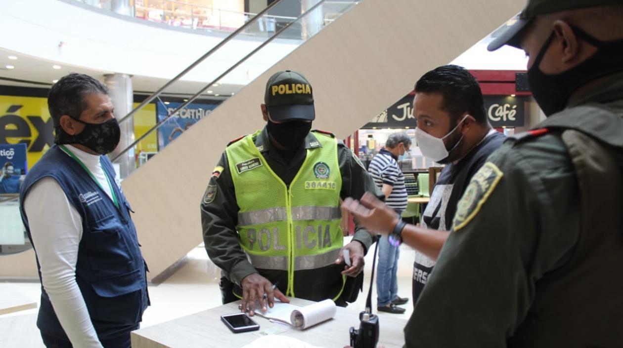 Personal de la patrulla Covid cerrando el Centro Comercial Viva Barranquilla.