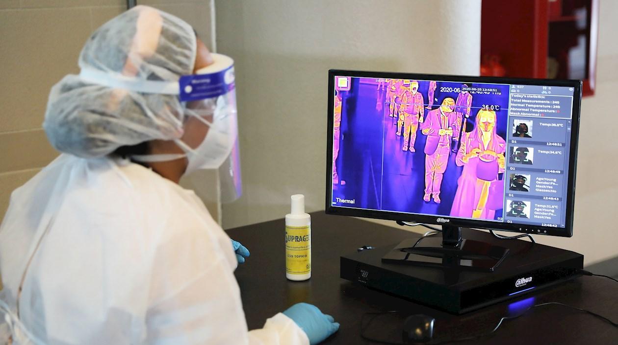 Una trabajadora revisa este jueves la temperatura de quienes llegan al Aeropuerto Internacional El Dorado, en Bogotá.