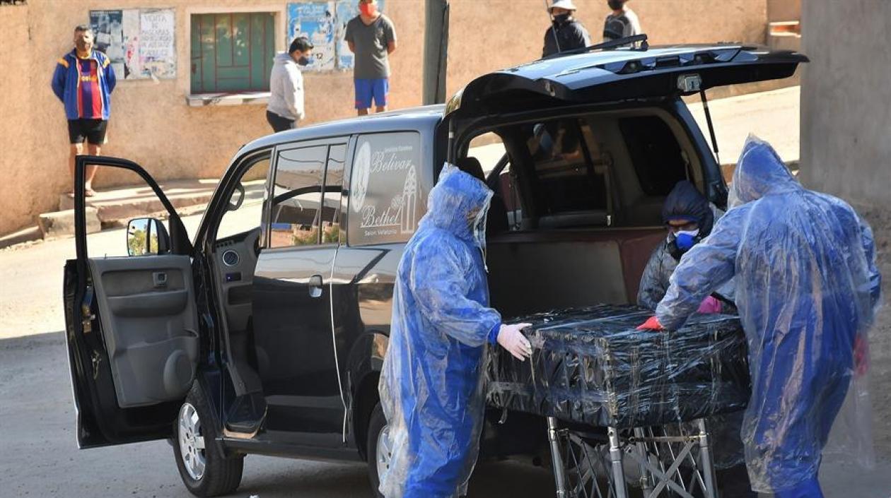 Empleados de una funeraria retiran el cuerpo sin vida de un hombre que permaneció durante horas abandonado en una calle, este domingo en Cochabamba.