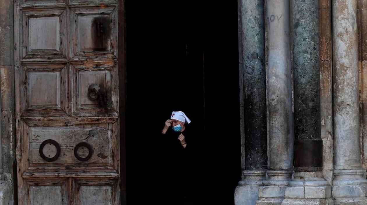 Una monja con mascarilla sale de iglesia del Santo Sepulcro, en Jerusalén.