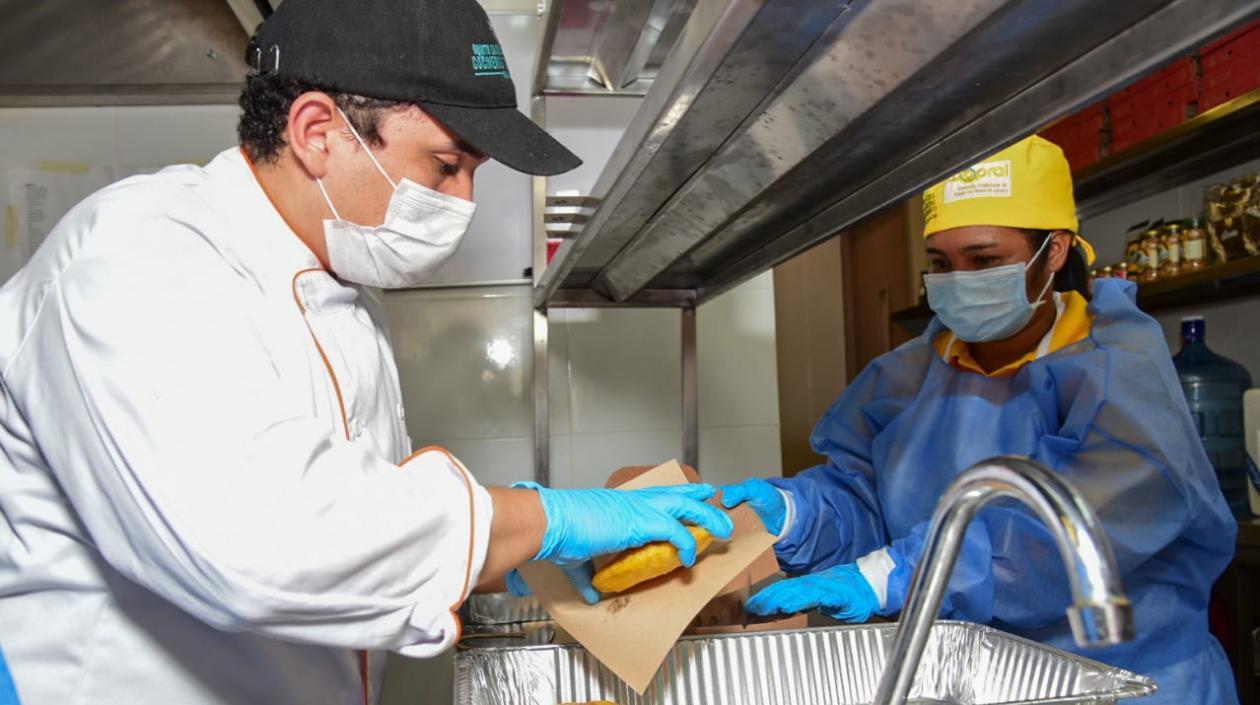 Una de las matronas empacando una arepa de huevo.