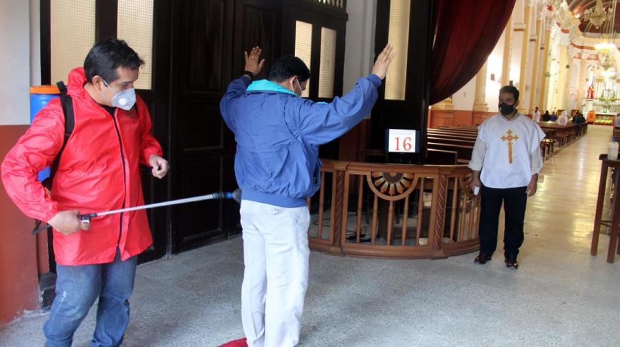 Personal de la Catedral realiza la desinfección de fieles que ingresan a un oficio religioso, este sábado en Santa Cruz (Bolivia). 