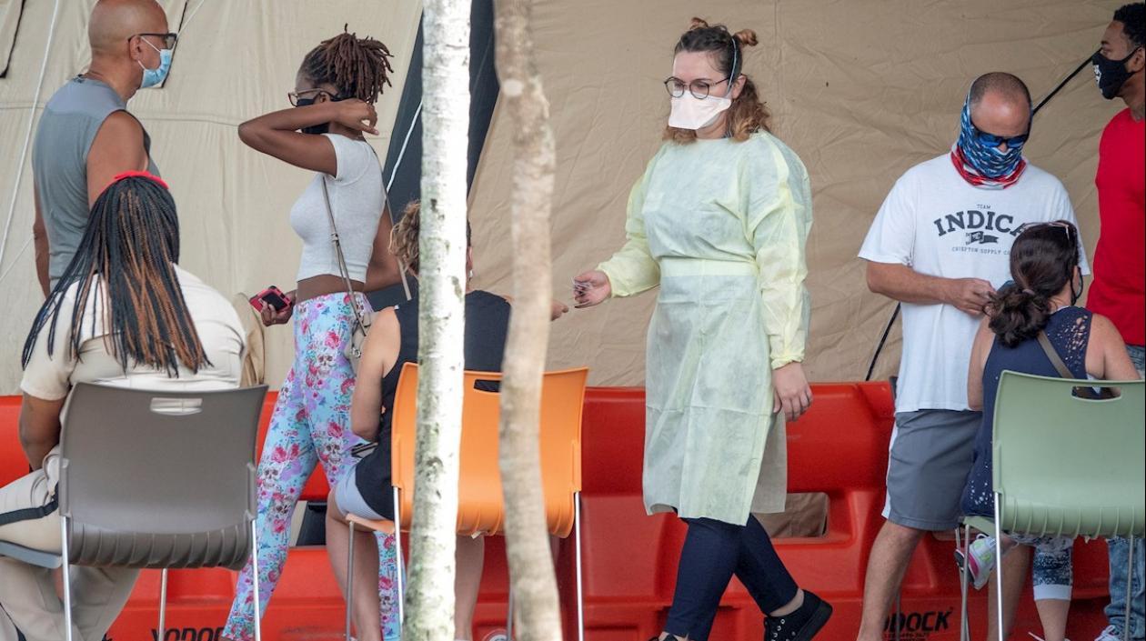 En la imagen, algunas personas usan máscaras y esperan para ingresar al Memorial Regional Hospital en Hollywood, Florida, EE.UU.